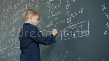 小角度观看聪明的小学生在<strong>黑板上用粉笔</strong>书写公式